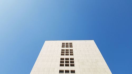 Low angle view of modern building against blue sky