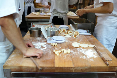 Midsection of people working at kitchen in restaurant 