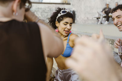 Non-binary person dancing with friends at party