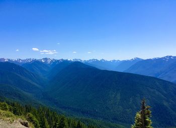 Scenic view of mountains against blue sky