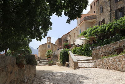 Footpath amidst buildings against sky in city