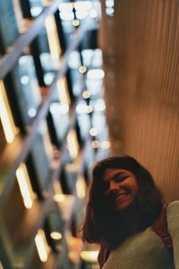 Low angle portrait young woman standing in illuminated room