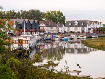 Buildings by lake against sky