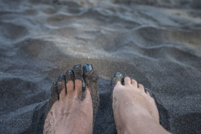 Low section of woman on sand at beach