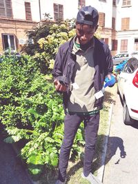 Full length of young man standing against plants