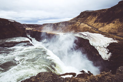 Scenic view of waterfall against sky