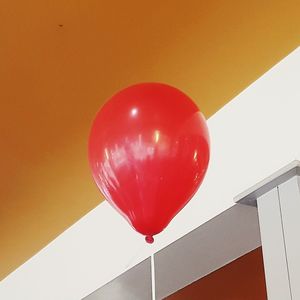 Low angle view of red balloon against built structure