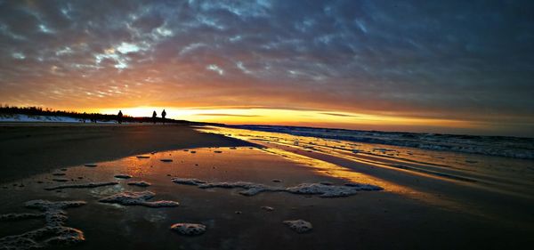 Scenic view of beach against sky during sunset