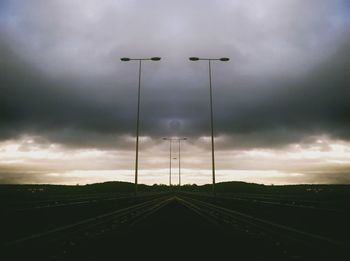 Road passing through landscape against cloudy sky