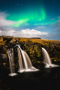 Scenic view of waterfall against sky at night