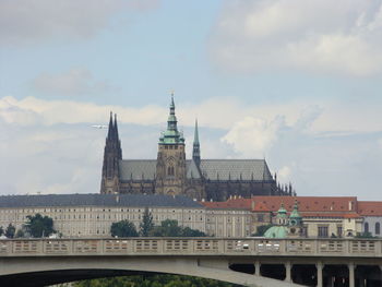 St vitus cathedral in prague against cloudy sky above the bridge