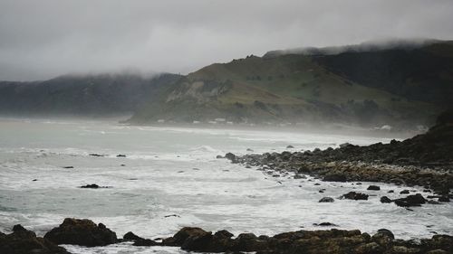 Scenic view of sea and mountains against sky