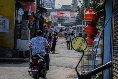 Rear view of people riding bicycle on road