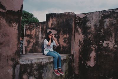 Full length of woman sitting against sky