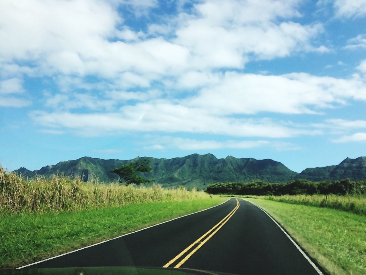 transportation, the way forward, road, sky, country road, diminishing perspective, mountain, landscape, vanishing point, road marking, cloud - sky, tranquil scene, cloud, nature, grass, countryside, mountain range, tranquility, car, non-urban scene