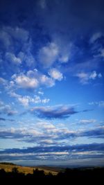 Low angle view of silhouette trees against sky