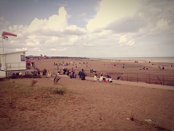 Panoramic view of people on beach against sky