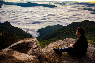 Side view of woman sitting on rock