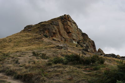 Low angle view of rock formations against sky