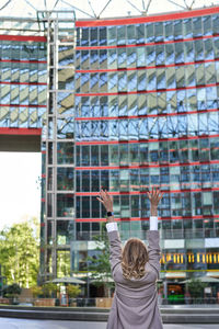 Rear view of woman standing against buildings