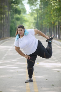 Full length of woman exercising on road