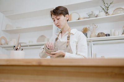 Side view of young woman working at home
