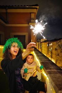 High angle view of woman celebrating new year from her terrace at night