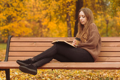 Woman sitting on bench in park