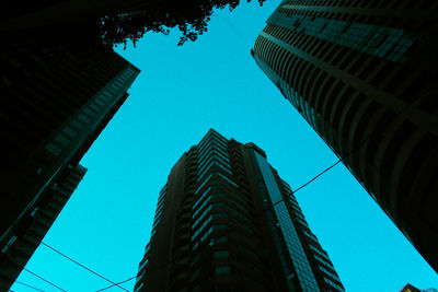 Low angle view of skyscrapers against clear blue sky