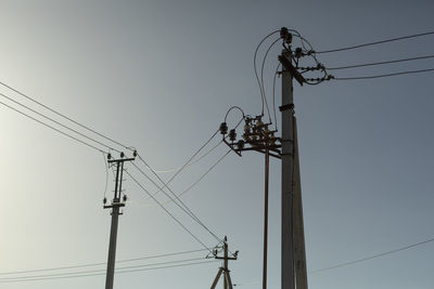 Low angle view of electricity pylon against clear sky