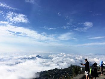 People photographing against sky