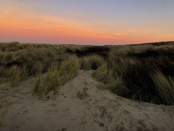 Scenic view of land against sky during sunset