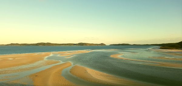 Scenic view of beach against clear sky during sunset