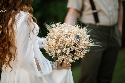 Midsection of woman with bouquet