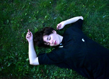 High angle view of sleeping woman lying on grassy field