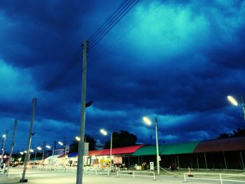Low angle view of illuminated street against sky at dusk