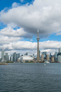 Sea by modern buildings against sky in city