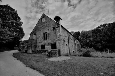 Old building by road against sky