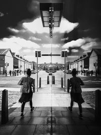 Full length rear view of couple walking in city