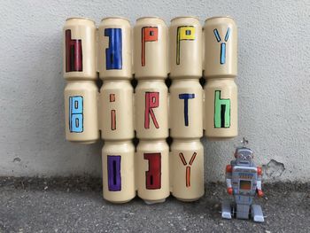 Happy birthday painted on beer cans with a tin toy robot