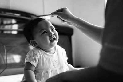 Mother combing baby girl at home