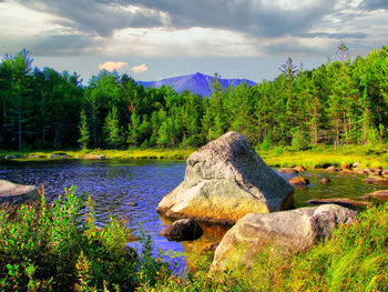 Scenic view of rocks by lake against sky