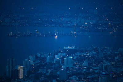 Aerial view of cityscape by bay at night