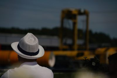 Rear view of person wearing hat against sky