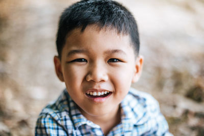 Close-up portrait of cute boy standing outdoors