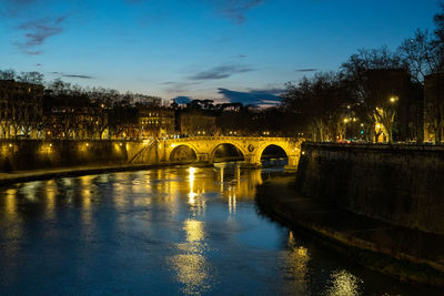 Bridge over river against sky at sunset