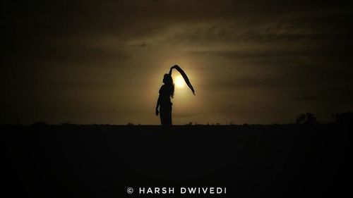 Silhouette of man standing against sky at night