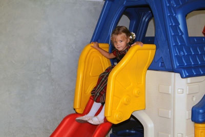 Portrait of cute girl sitting on slide