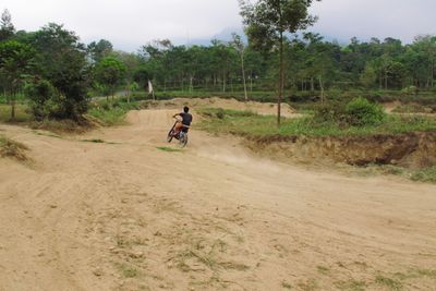 Man riding motorcycle on dirt road
