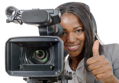 Portrait of young woman photographing against white background